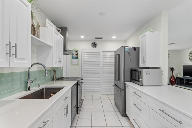 kitchen featuring appliances with stainless steel finishes, light countertops, white cabinetry, and a sink