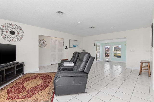 living area with light tile patterned floors, baseboards, visible vents, and recessed lighting