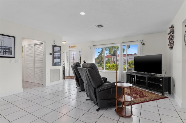 living area with light tile patterned floors, baseboards, and visible vents