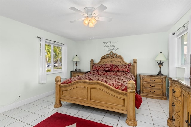 bedroom with ceiling fan, baseboards, and light tile patterned floors