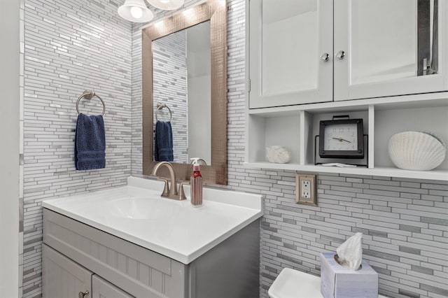 bathroom featuring decorative backsplash, tile walls, and vanity