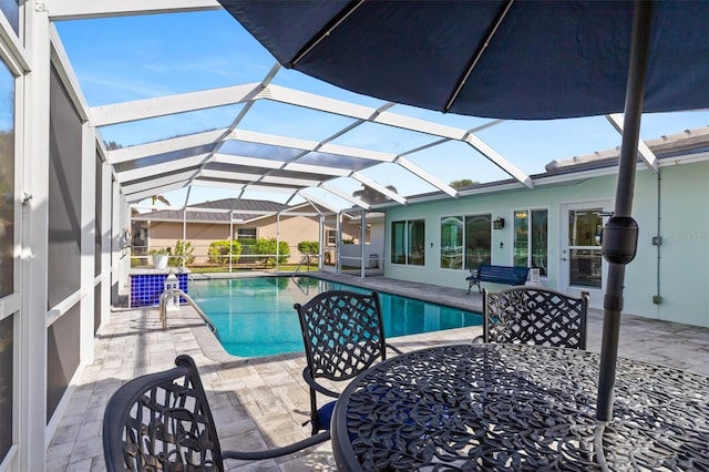 outdoor pool featuring outdoor dining area, a patio area, and a lanai