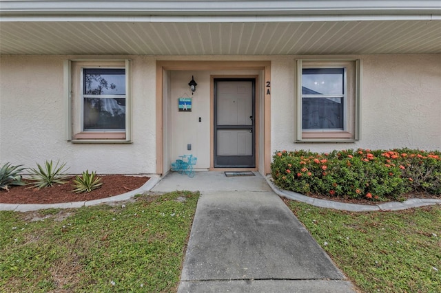 property entrance with a lawn