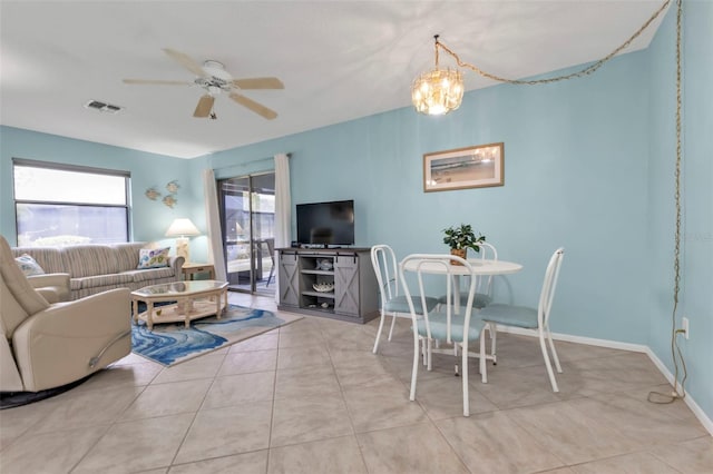 tiled living room featuring ceiling fan with notable chandelier