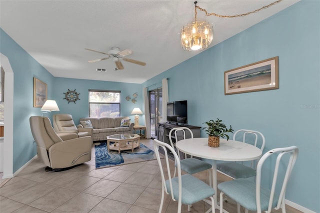 tiled dining area with ceiling fan with notable chandelier