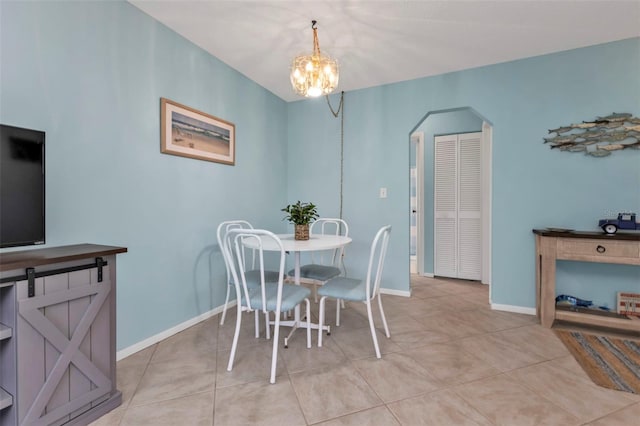 dining room with light tile patterned floors and an inviting chandelier