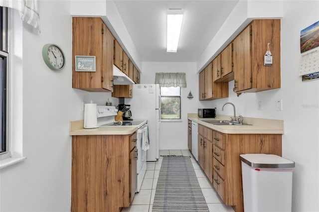 kitchen with white appliances, sink, and light tile patterned floors