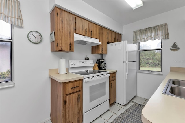 kitchen with light tile patterned flooring, white appliances, and sink