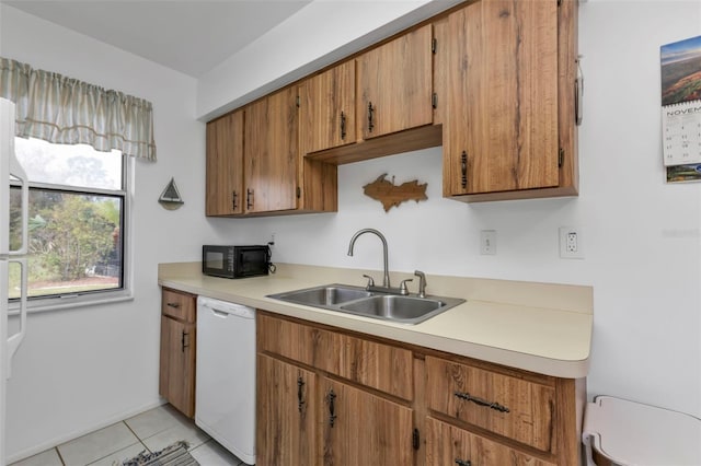 kitchen featuring white dishwasher, sink, and light tile patterned floors