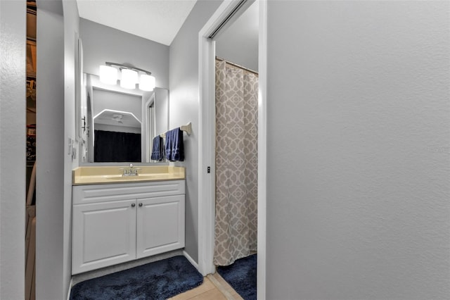 bathroom featuring curtained shower, vanity, and tile patterned floors