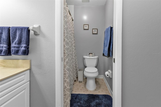 bathroom with a shower with curtain, vanity, tile patterned floors, and toilet