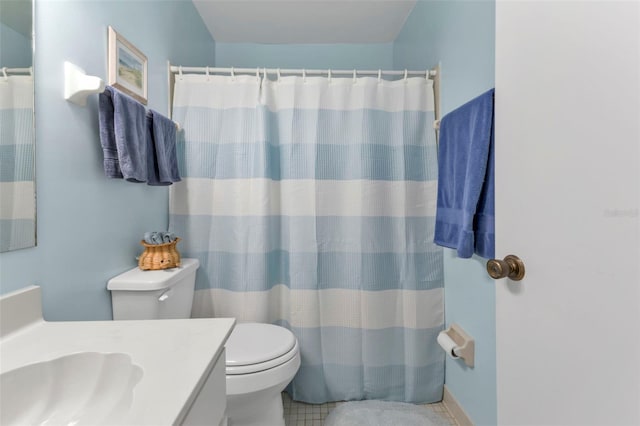 bathroom featuring toilet, vanity, a shower with shower curtain, and tile patterned flooring