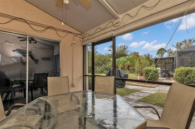 sunroom / solarium featuring ceiling fan and vaulted ceiling