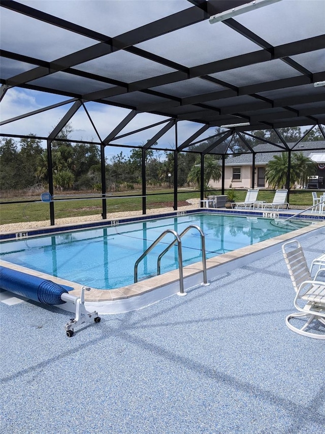 view of swimming pool featuring a patio and glass enclosure