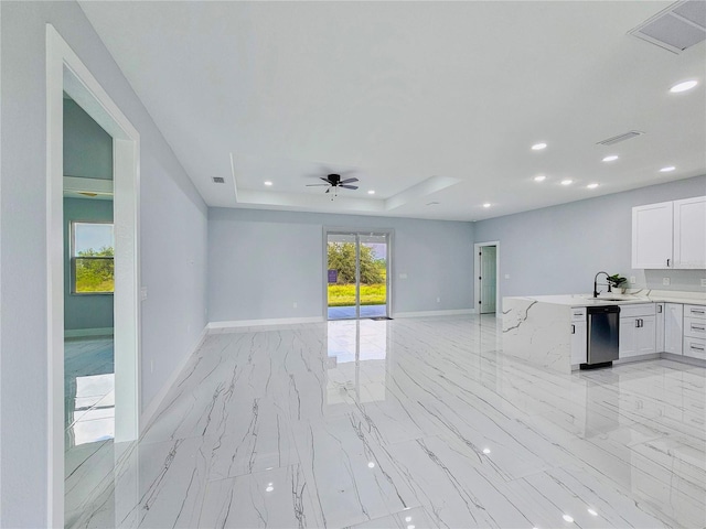 unfurnished living room featuring ceiling fan, a raised ceiling, and sink