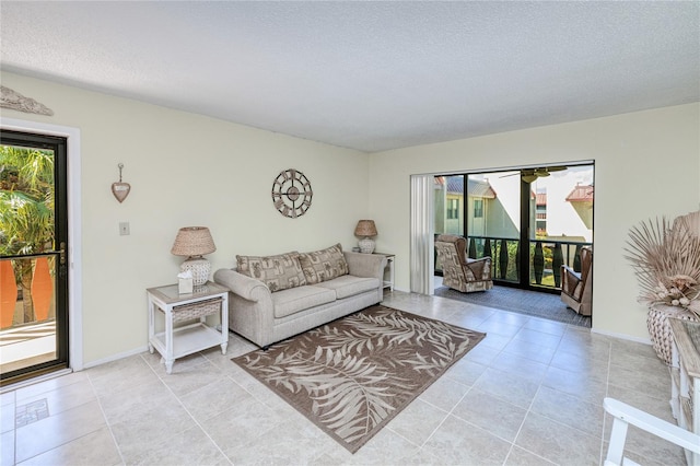 living room with a textured ceiling and light tile patterned flooring