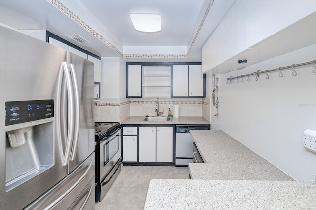 kitchen with light tile patterned flooring, white cabinets, stainless steel appliances, and sink