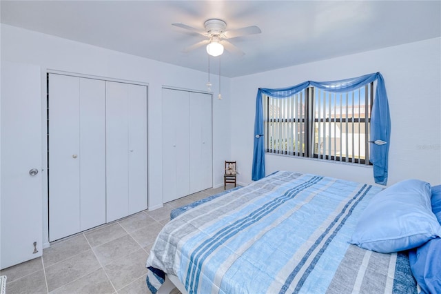 tiled bedroom with multiple closets and ceiling fan