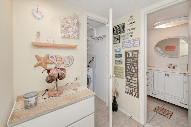 bathroom with washer / dryer, a textured ceiling, vanity, and tile patterned flooring