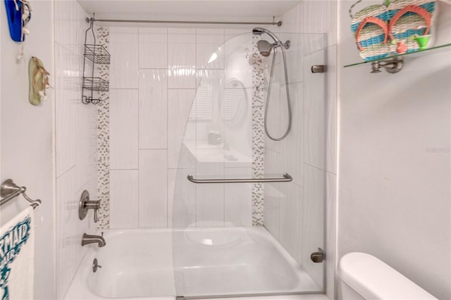 bathroom featuring tiled shower / bath combo and toilet