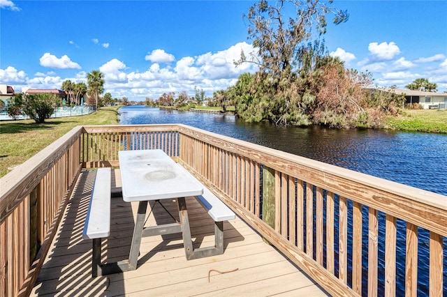 dock area with a lawn and a water view