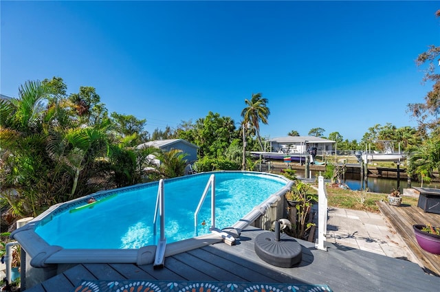 view of pool featuring a patio area and a water view