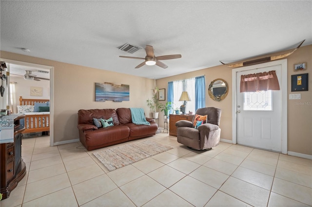 living room featuring light tile patterned flooring, a textured ceiling, and ceiling fan