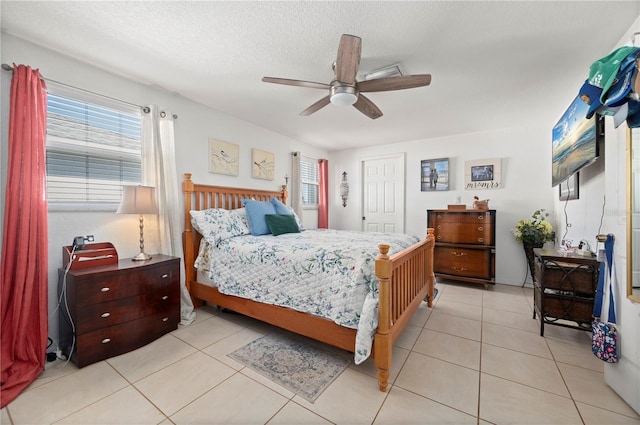 bedroom with a textured ceiling, light tile patterned floors, and ceiling fan