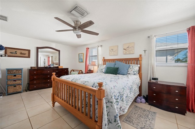 tiled bedroom featuring a textured ceiling and ceiling fan