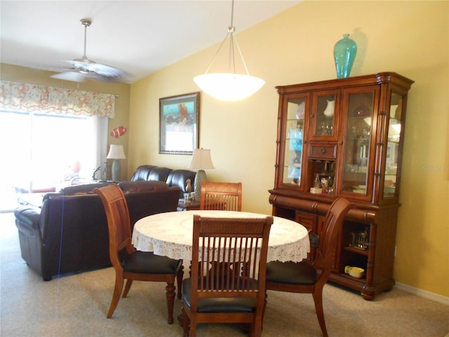 dining room with ceiling fan, lofted ceiling, and light colored carpet