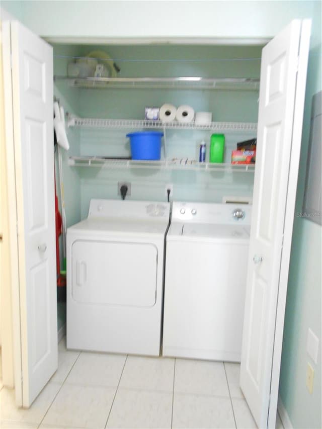 laundry area featuring washer and dryer and light tile patterned floors