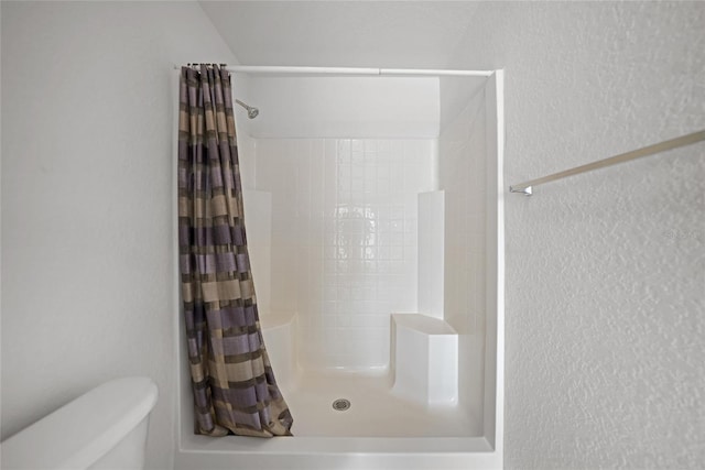 bathroom with toilet and curtained shower