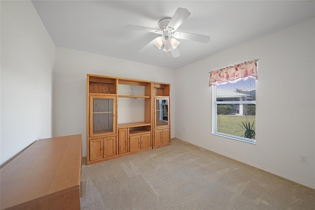 unfurnished living room with ceiling fan and light colored carpet