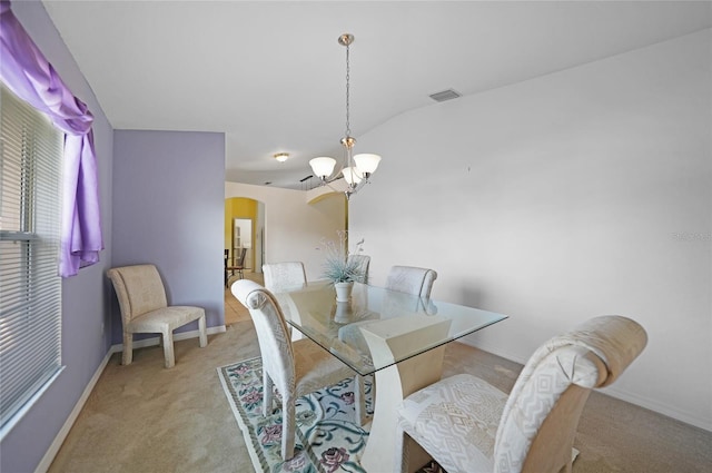 dining room featuring vaulted ceiling, a chandelier, and light colored carpet