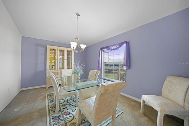 carpeted dining space featuring a chandelier