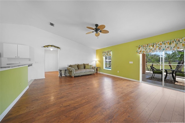 unfurnished living room with ceiling fan, vaulted ceiling, and dark hardwood / wood-style flooring