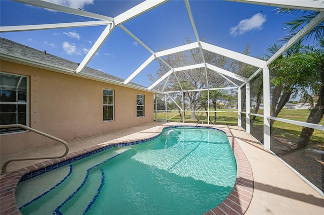 view of pool featuring a patio, glass enclosure, and a lawn