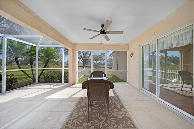 sunroom with a water view and ceiling fan