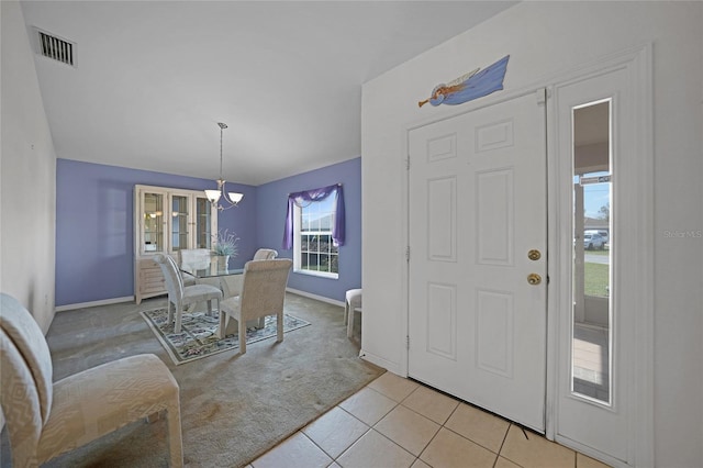 carpeted dining area featuring a chandelier