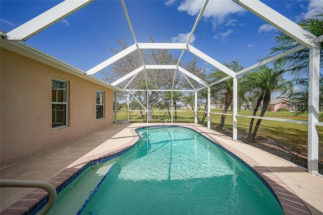 view of pool featuring a yard, a patio area, and glass enclosure