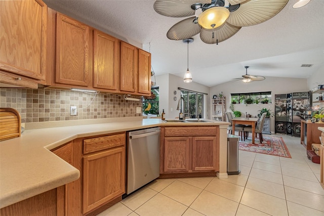 kitchen featuring vaulted ceiling, dishwasher, decorative backsplash, sink, and light tile patterned flooring