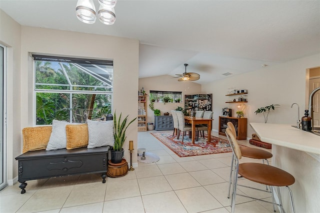 tiled dining room featuring ceiling fan and vaulted ceiling