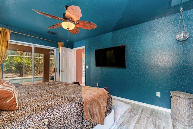 bedroom with access to outside, wood-type flooring, and ceiling fan