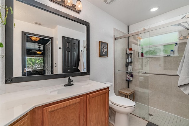 bathroom with vanity, toilet, and a shower with door