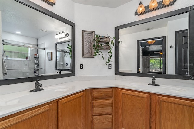 bathroom featuring an enclosed shower, vanity, and a textured ceiling