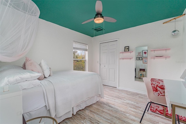 bedroom with a closet, ceiling fan, and light hardwood / wood-style flooring