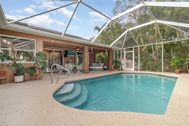 view of pool with glass enclosure, ceiling fan, and a patio