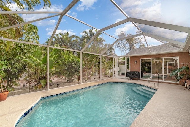 view of swimming pool featuring glass enclosure and a patio area