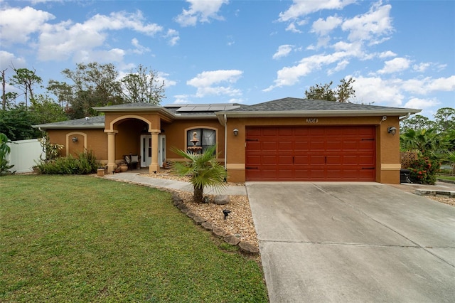 view of front of home with a garage, a front lawn, and solar panels