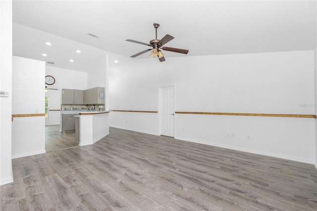 unfurnished living room with vaulted ceiling, light wood-type flooring, and ceiling fan